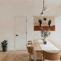 Modern dining room with desert-themed wall hanging by Clay Banks