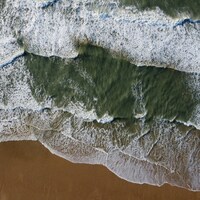 Waves crashing on a sandy beach from above by Huseyin Benli