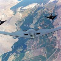 B2 stealth bomber being escorted by two F117 fighter jets