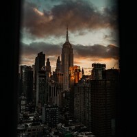 Empire state building at sunset with dramatic clouds by Mario Scheibl