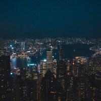 Vast cityscape illuminated at night with a dark sky by Willian Justen de Vasconcellos