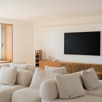 Modern living room with large sectional sofa and tv by Caroline Badran