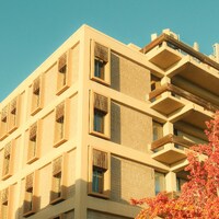 Modern building with balconies and autumn foliage by Dan Begel