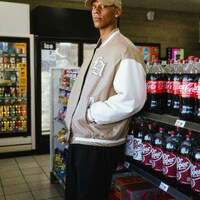 Man in baseball cap and bomber jacket in store by Jadon Johnson