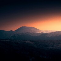 Mountain silhouette against a vibrant sunset sky by Daniil Silantev
