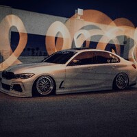 White sedan with light trails forming the number 2023 by Andy Illarionov