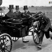 Beggar catches up with the carriage of King George the V, London, 1920.