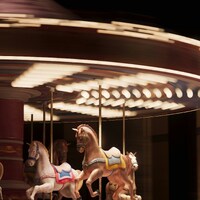 Motion-blurred carousel with horses at night by Planet Volumes