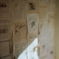 Wall covered with old papers and sunlight by Katelyn Warner