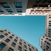 Buildings surrounding a bright blue sky by Wolfgang Weiser