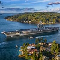 USS Carl Vinson squeezing past houses on Puget Sound.