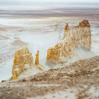 Majestic white rock formations in a vast, desolate desert by Kilic-Emre Akdag