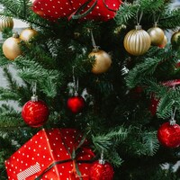 Christmas tree with red and gold ornaments and gifts by Fujiphilm
