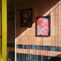Two framed artworks hang on a tiled wall by Maximilian Bungart
