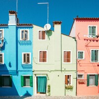 Vibrant blue, green, and pink houses against a clear sky by Rafael Peier