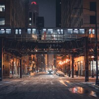 Train passing over a snowy city street at night by Tobias Reich