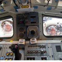 NASA astronauts (Atlantis) photographed through window on spacewalk