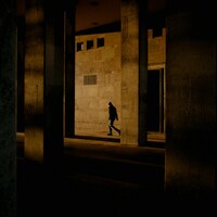 Silhouette of a person walking in a dark urban underpass by Pavel Moiseev