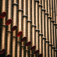 Close-up of golden organ pipes with red accents by Vitalii Onyshchuk