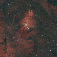 Cosmic nebula with glowing red gas and scattered stars by Joel Henry