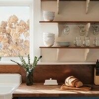 Rustic kitchen counter with bread and dishes by Clay Banks